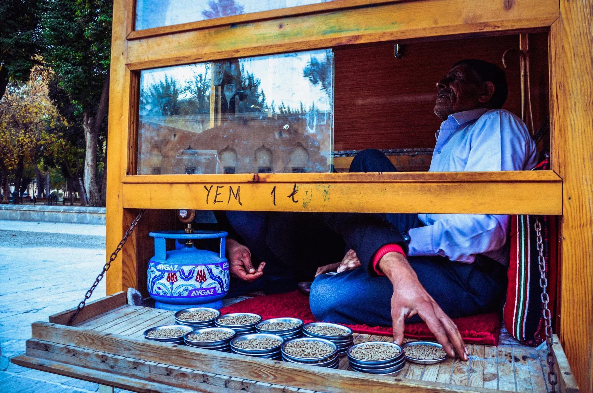A street vendor framed by a wooden kiosk