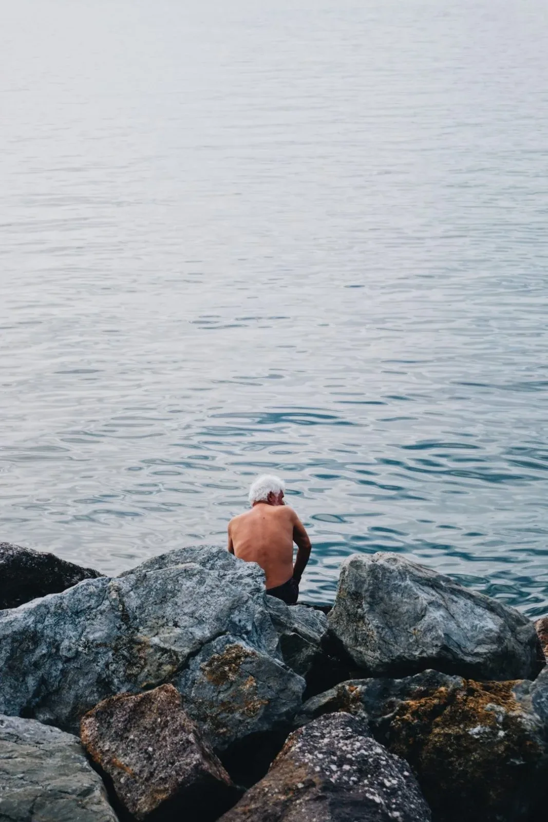 A solitary person sitting beside the sea